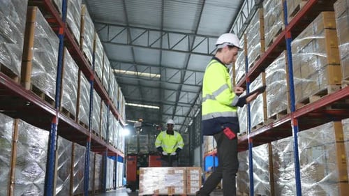 Worker in auto parts warehouse use a handcart to work to bring the box of auto parts