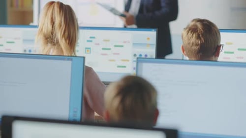 Clase de escuela primaria: el profesor usa una pizarra digital interactiva y explica la lección a diversos alumnos