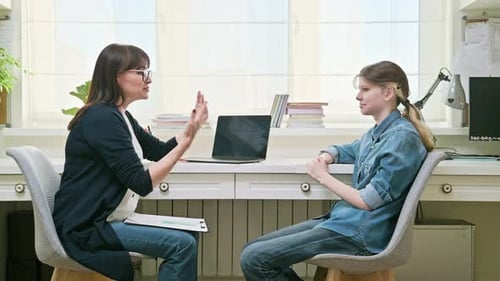 Woman Psychologist Counselor Talking with Girl Child