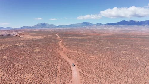 Aerial, road trip camper van driving on desert road in Utah vanlife
