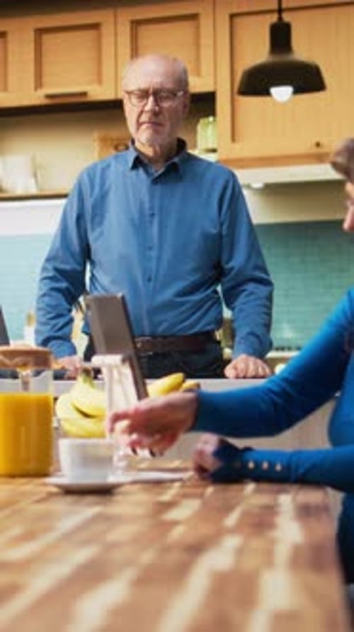 Senior Couple Relaxing in Kitchen Drinking Coffee