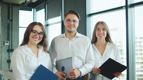 Team Members Pose Confidently in Modern Office Setting Showcasing Collaboration and Professionalism