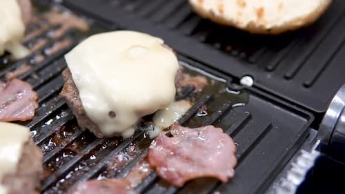 Burgers Grilling With Cheese and Bacon