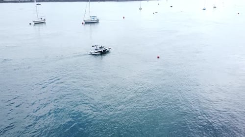 Aerial view motorboats travelling Seaside town river Conwy harbour marina slow tracking right