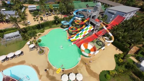 Tourists Enjoying Colorful Water Slides at Tropical Resort