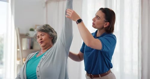 Woman Assists Senior Woman with Arm Stretching Exercise