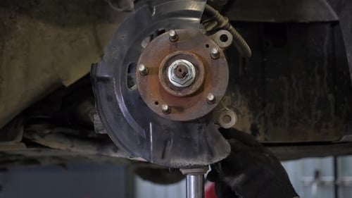 Closeup of a Mechanic Replacing Brake Pads on a Car Wheel at a Service Station