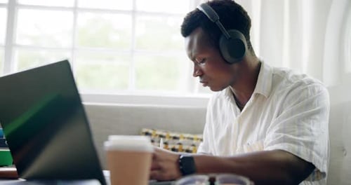 University, remote work and black man with headphones on laptop for online learning