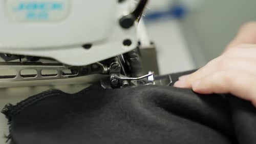 A Seamstress Sews Clothes on a Closeup Machine