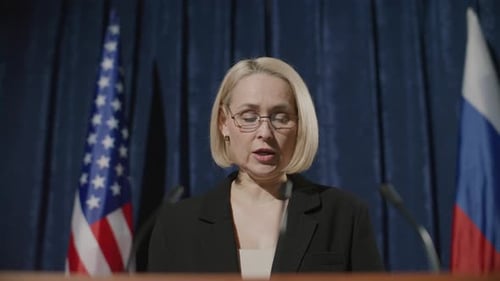Woman at Press Conference Between Flags