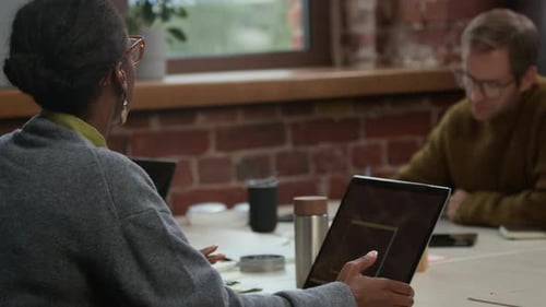 Diverse Couple of Developers Discussing Program Coding on Laptop in Office