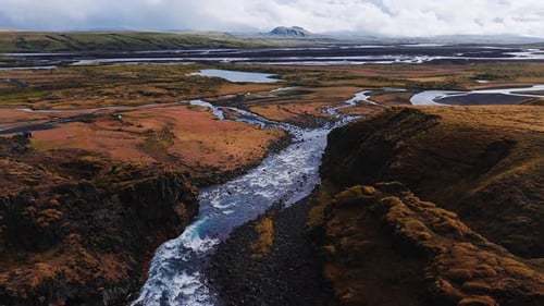Aerial View of Glacial River Through Basalt Canyon in Iceland