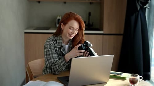 Woman Inspecting Digital Camera at Home Office