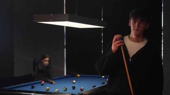 A Young Guy Playing Billiards Looks Directly Into the Camera to Prepare ...