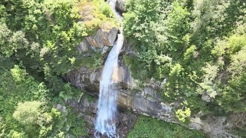Scenic Waterfall Flowing Through Lush Forest