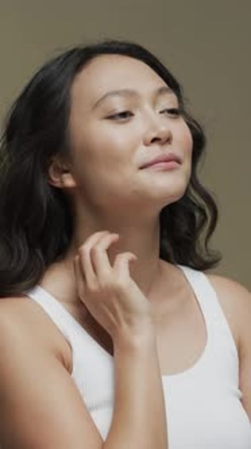 Attractive Woman Gently Touches Her Face and Neck