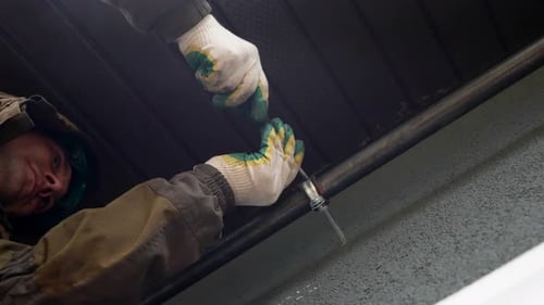 Handyman Installing Metal Pipes on Facade of Building Connecting Gas or Water Supply System
