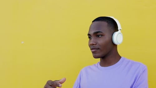 Cool Young Adult Grooves to Music Headphones Yellow Wall
