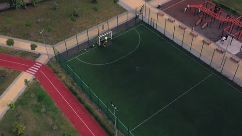Boys Play Soccer on the Artificial Green Court Turf