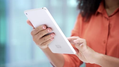 Close up of female hands holding using digital tablet in business office. African american business