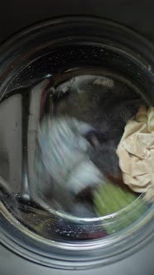 Laundry Spinning Inside Front Load Washing Machine During Wash Cycle at Home