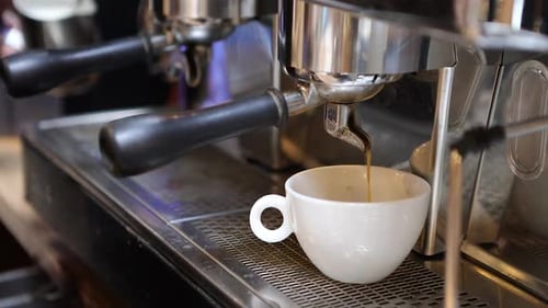 Espresso Machine Dispensing Coffee into White Cup