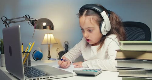 Little Schoolgirl Wearing Headphones Studying Online School With Tutor