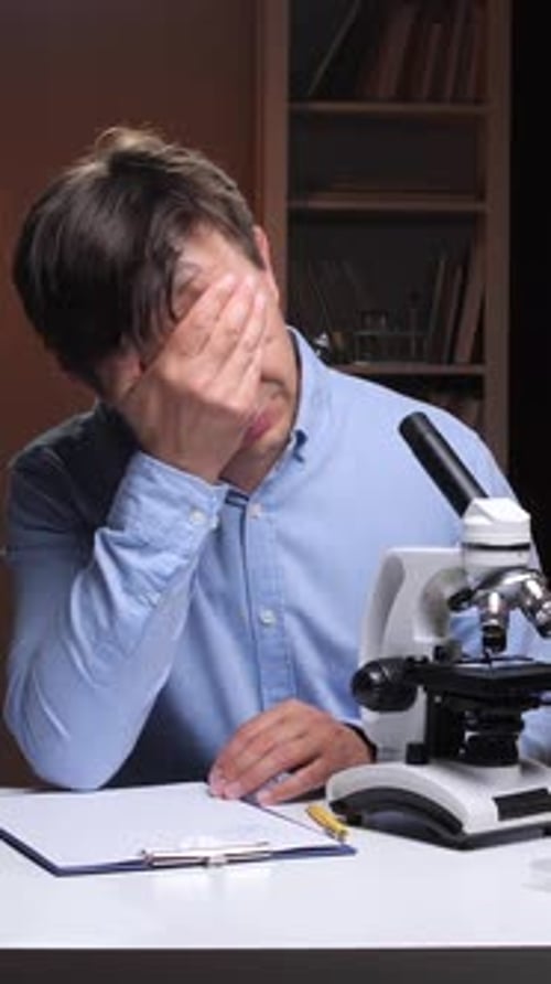 Adult Man Looking Through Microscope Gets Frustrated