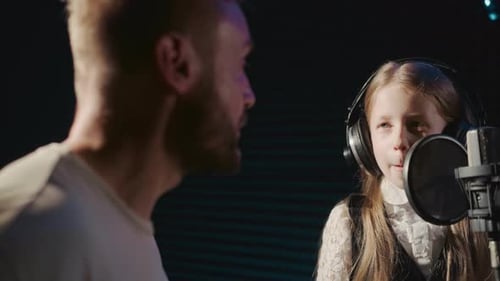 Girl Singing into Microphone in Recording Studio