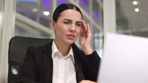 Business Woman Working in Office and Massaging Temples While Feeling Headache
