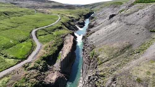 Sightseers On Unique Basalt Columns In Studlagil Canyon, East Iceland. Aerial Descending Shot