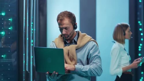 A Dedicated Professional Working Efficiently in a Data Center While Using a Headset and Laptop