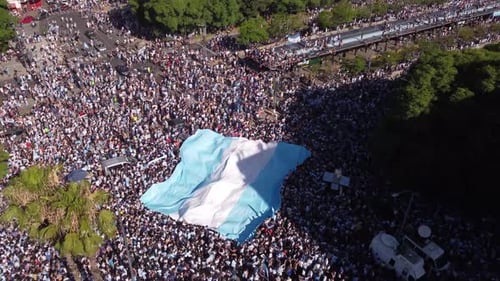 Eine
Menge Fans schwenkt die große argentinische Flagge auf einem überfüllten Platz in der Stadt Buenos Aires in Argentinien. Luftaufnahme, trocken