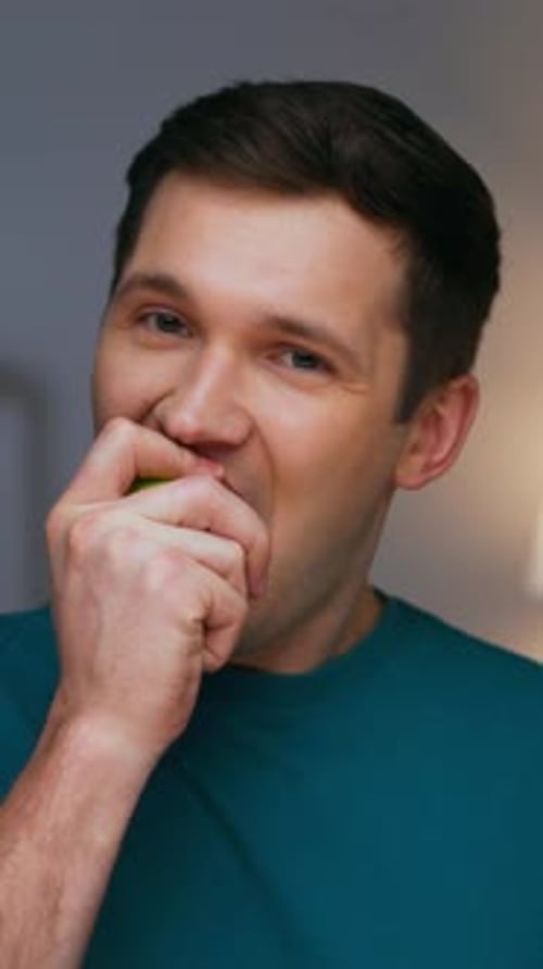 Portrait of Adult Man Eating Healthy Food of Green Apple and Looking at Camera