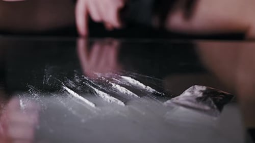 Cinematic Shot, White Powder Prop In Lines As Blurred Hand Moves In Background