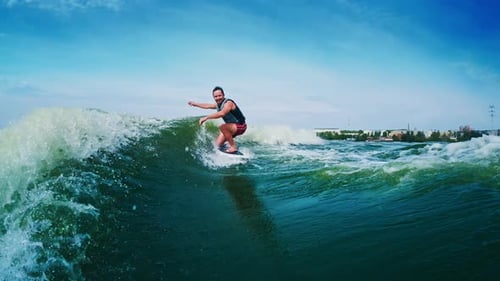 Wakesurfing. Man rides the boat's wake on the freshwater lake at sunny day