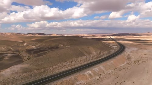 Empty Desert highway mountain road with Blue cloudy sky