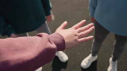 Hand Stretching Out with Team Members Joining Hands in Unity for Sports
