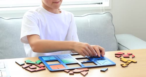 A Kid is Playing a Logical Wooden Game on the Table in the Room Educational Toy