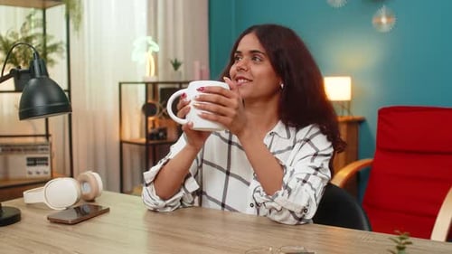 Woman Sipping Drink and Smiling Indoors