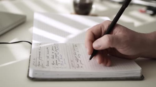 Man journaling thoughts into notebook