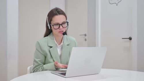 Woman with Headset in Call Center Doing Video Chat at Work