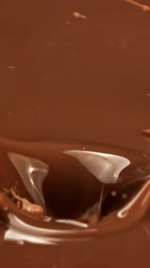 Super Slow Motion Dark Chocolate Chunks Fall Into Liquid Chocolate Filmed on a Highspeed Camera at