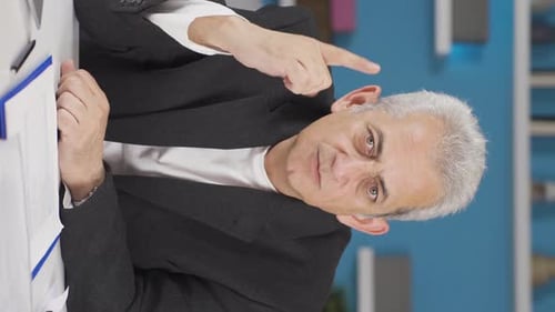 Vertical video of Home office worker man looking nervously at camera.