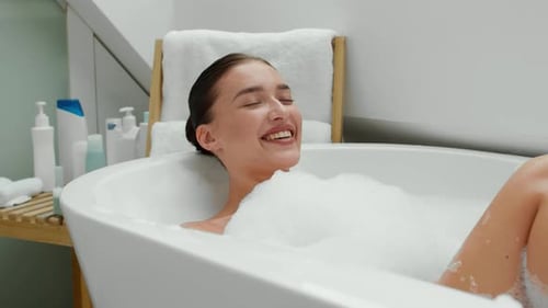 Woman Lying in Bubble Bath Laughing and Relaxing