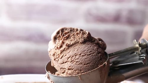 Hand Picking Ice Cream with a Spoon From a Bowl