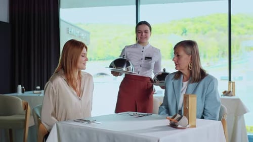 Footage of Two Women Sitting in Restaurant Waiting for Order Friendly Waitress Bringing Food to