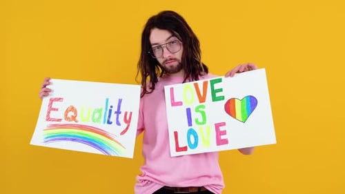 Attractive Gay Caucasian Bearded Man Holding a Protest Sign During a LGBT Pride Parade