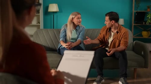 A Married Couple Quarreling at a Joint Appointment with a Psychotherapist Back View of Female