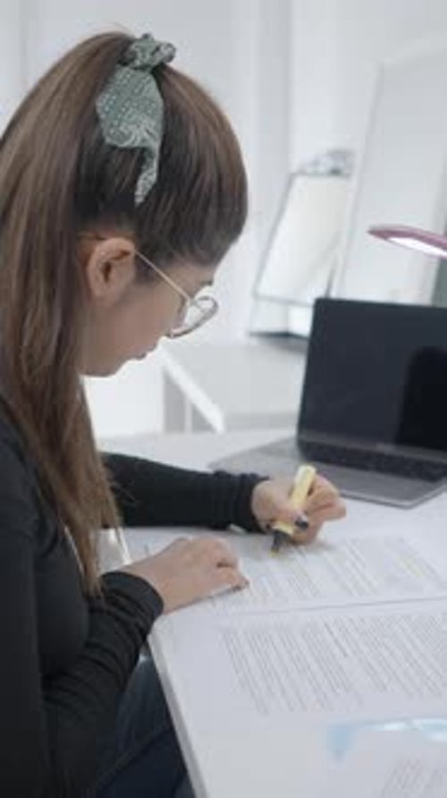 A Young Girl Sitting at a Study Table and Highlighting Her Study Material A Student of Colombian